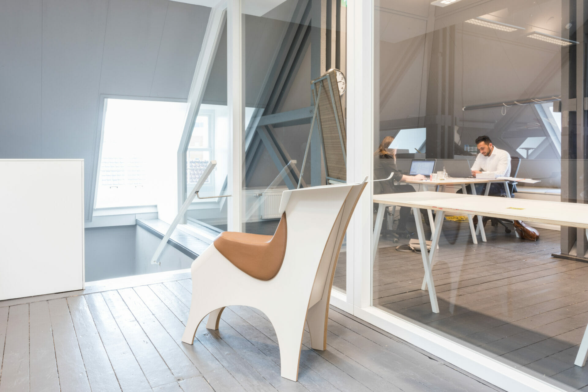 Een stijlvolle kantoorruimte met moderne witte kantoormeubelen, waaronder de Lande Torro stoel en bureaumeubelen, met twee mensen werkend aan een witte tafel.