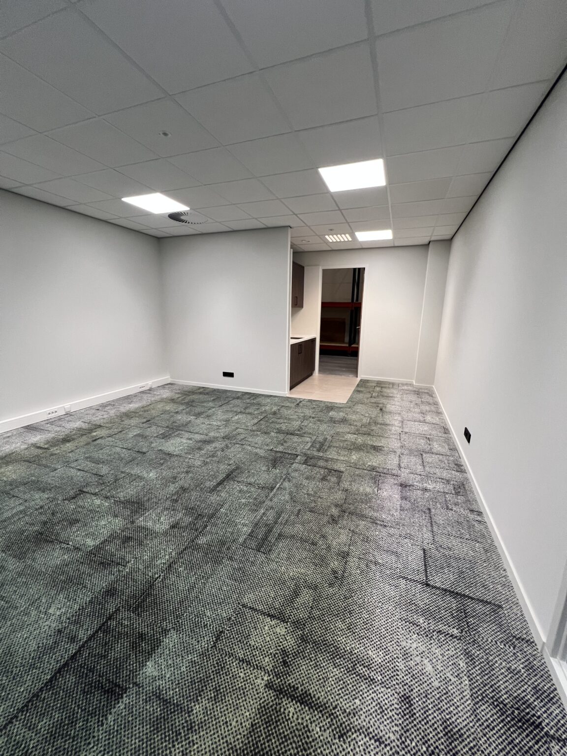 Leeg kantoor met moderne verlichting en patroon vloerbedekking.